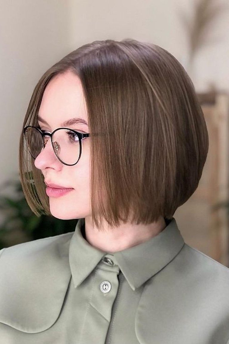 Centre-parted short bob worn with glasses, ends sitting cleanly at the jawline
