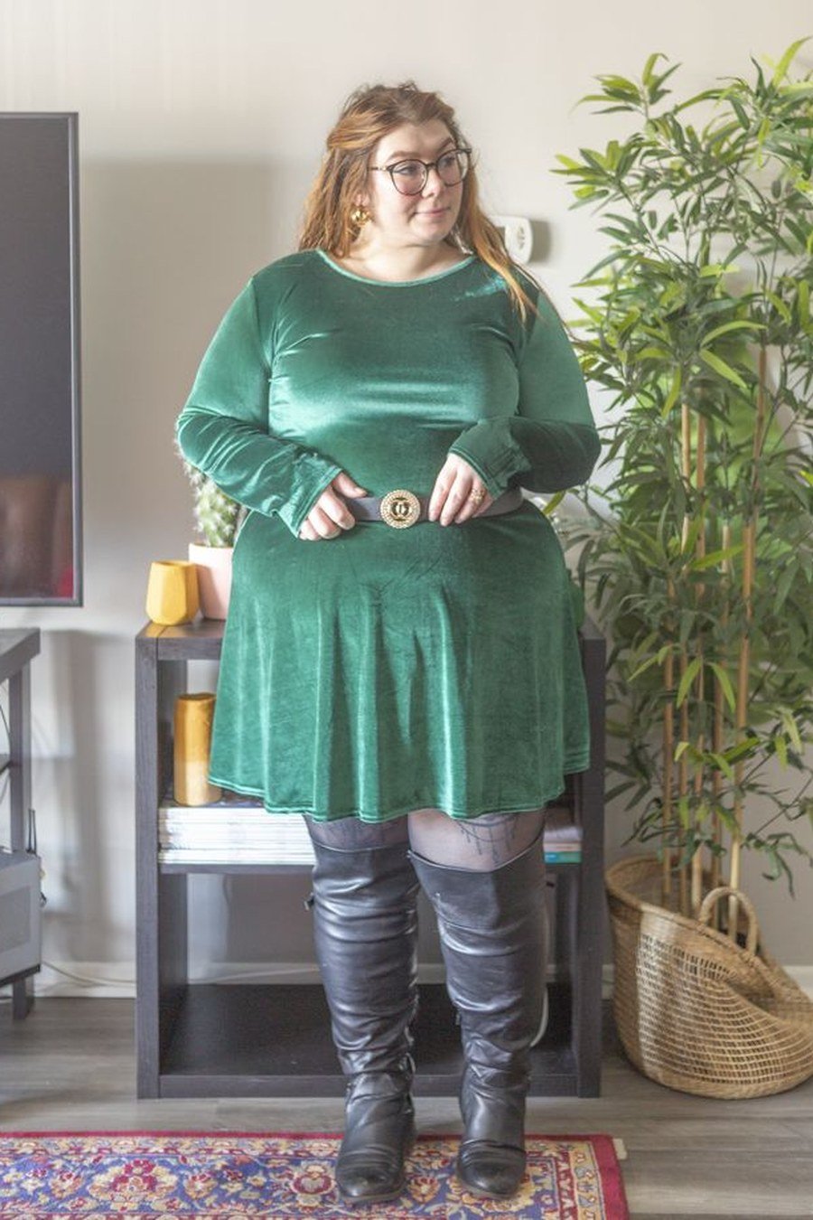 Green velvet belted mini dress with black knee-high boots