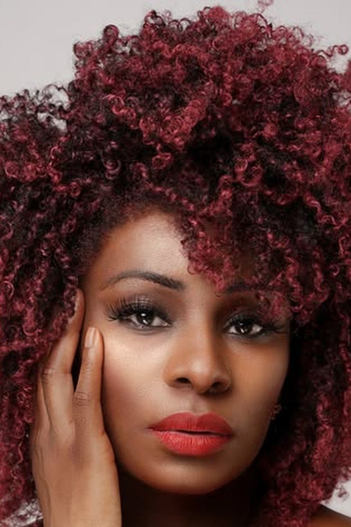 Voluminous natural curly hair in deep burgundy colour
