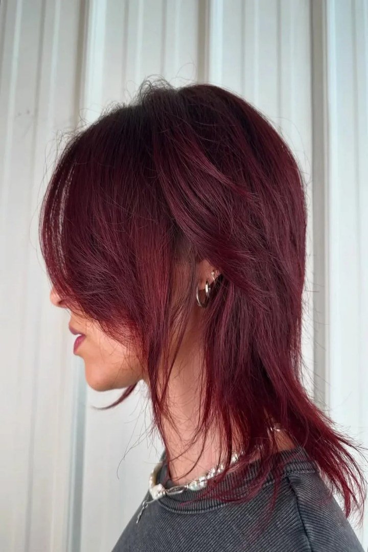 Shaggy layered burgundy haircut with textured wine-red layers