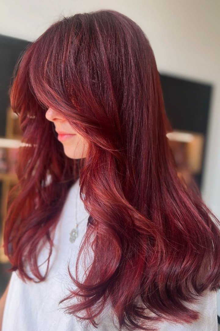 Burgundy hair with curtain bangs framing the face