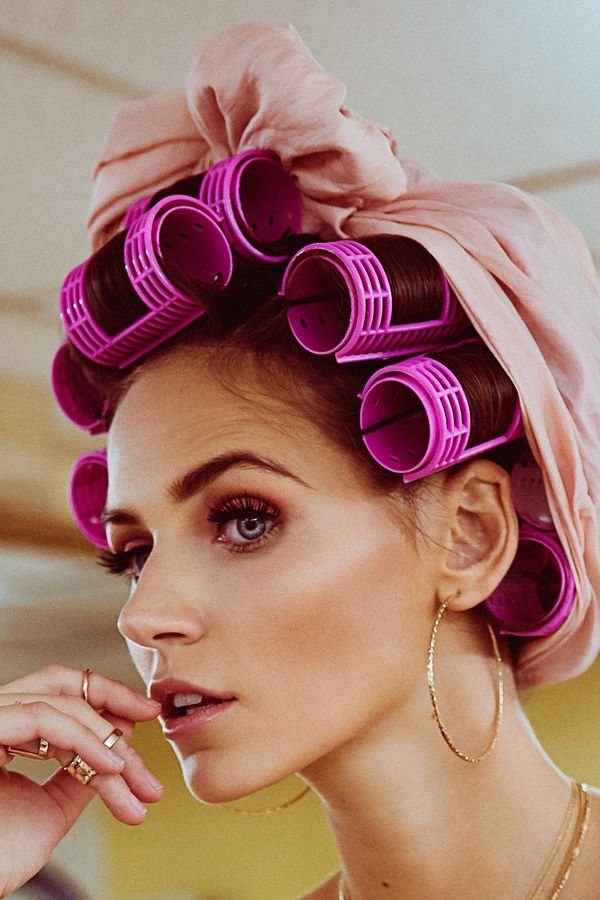 Woman with pink hot rollers and a silk scarf setting her blowout