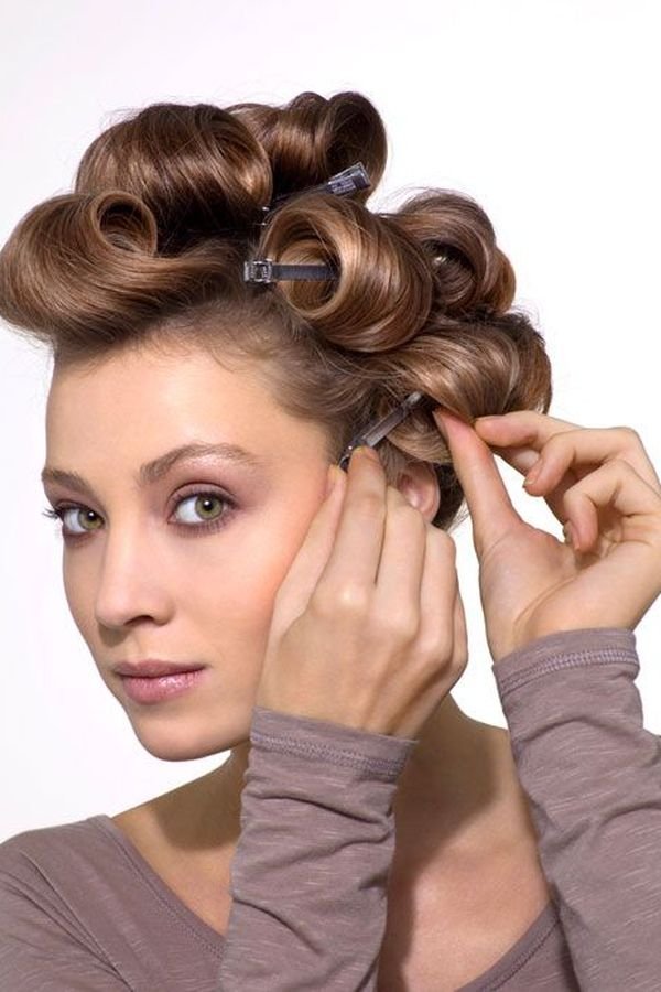 Woman setting pin curls with clips for a brushed-out 90s blowout