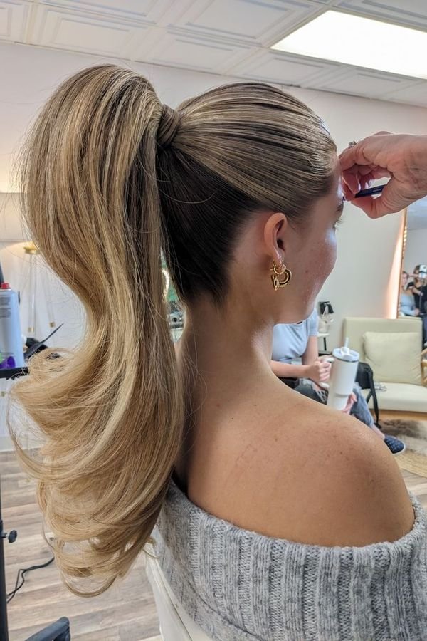 High ponytail with a smooth base and a voluminous curved tail