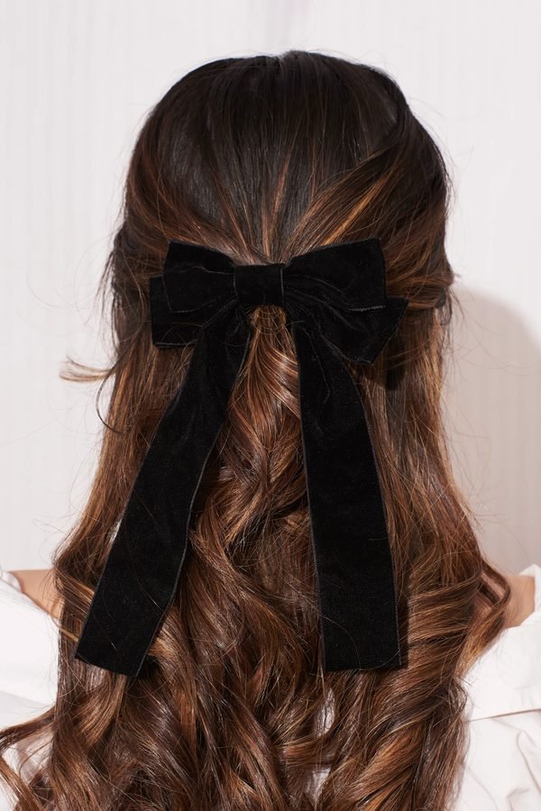 Black velvet long-tail bow on a wavy half-up hairstyle