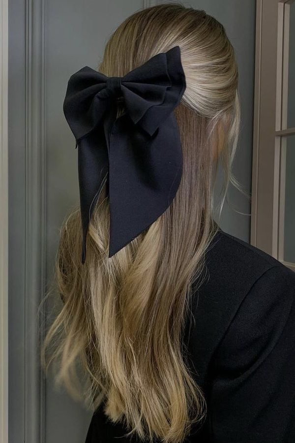 Oversized black bow on sleek straight hair