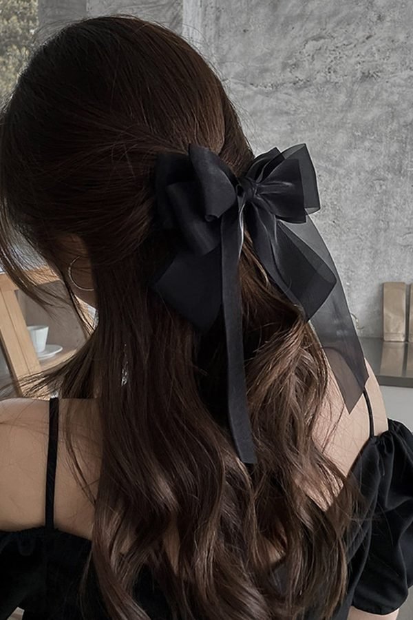 Black bow with sheer organza tails on dark waves