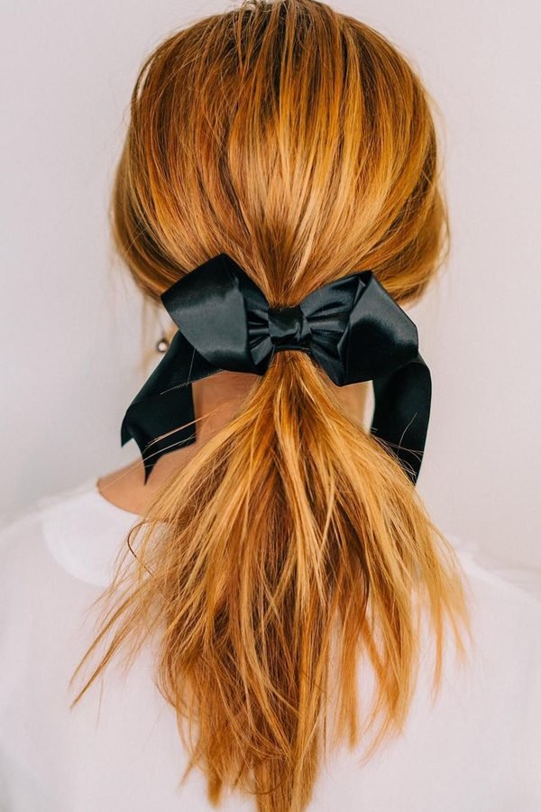 Copper ponytail tied with a black satin bow