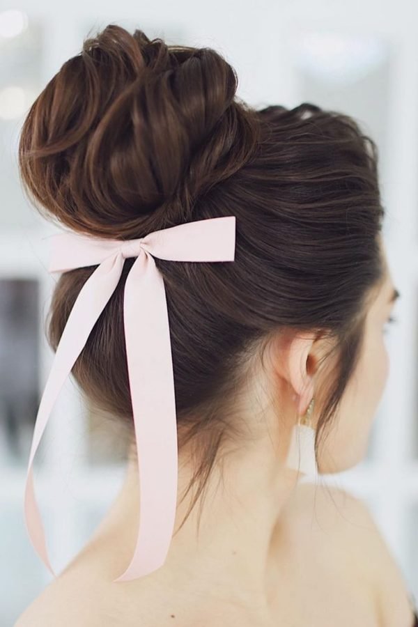 High bun with long pink ribbon tails