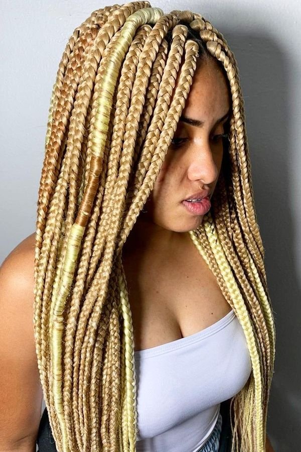 Honey blonde box braids worn long over the shoulders