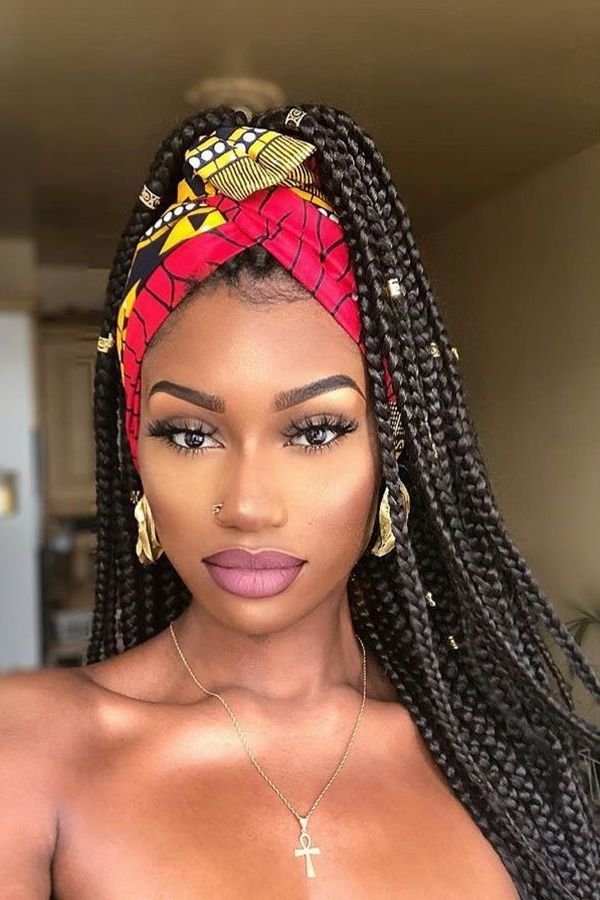 Long box braids styled with a red patterned headwrap