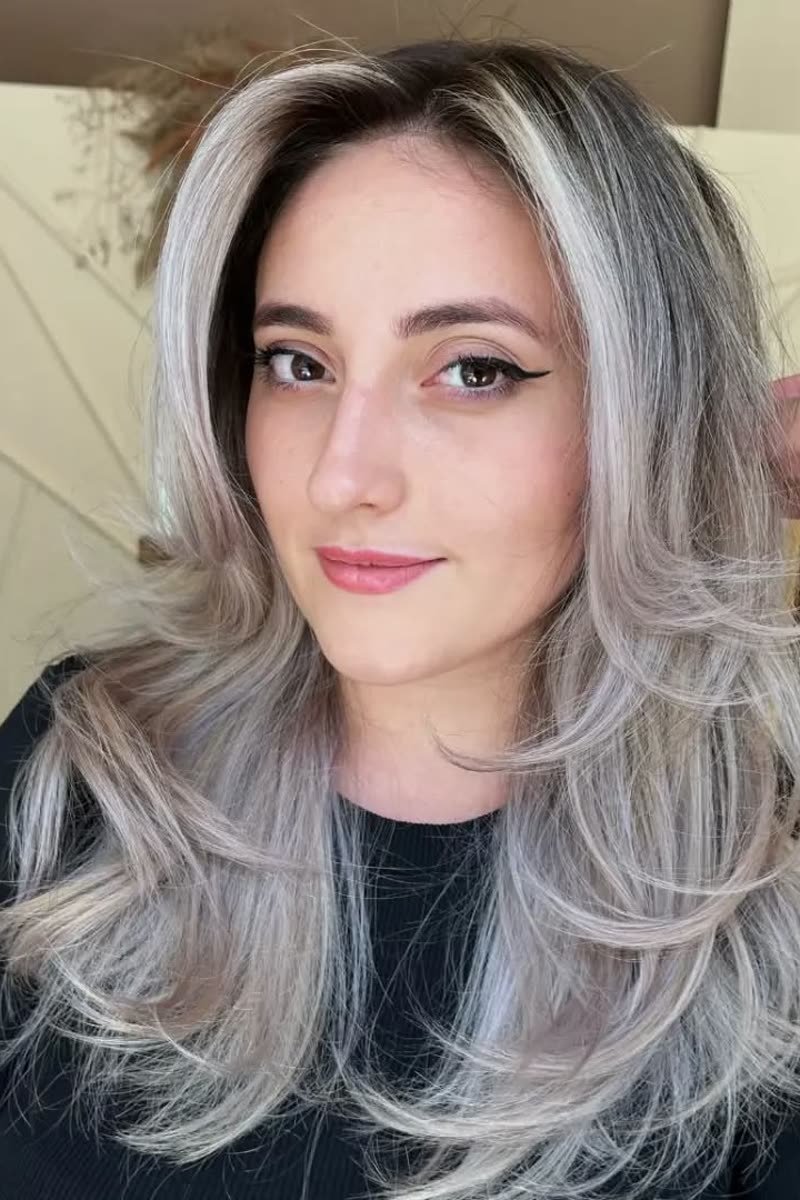 Icy blonde butterfly haircut with dark roots