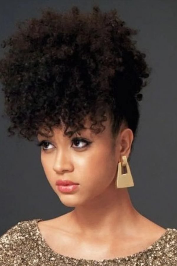 High curly puff hairstyle with gold statement earrings