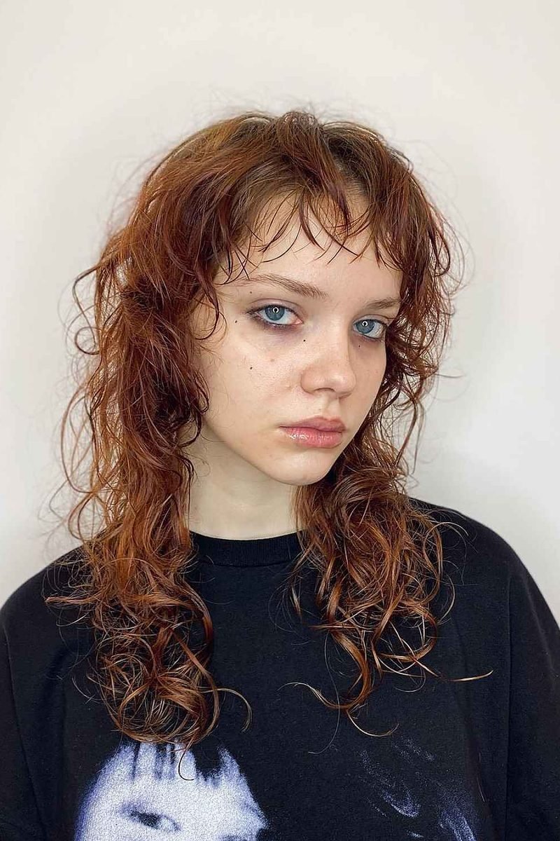 Copper-auburn wavy wolf cut with wispy bangs, front view