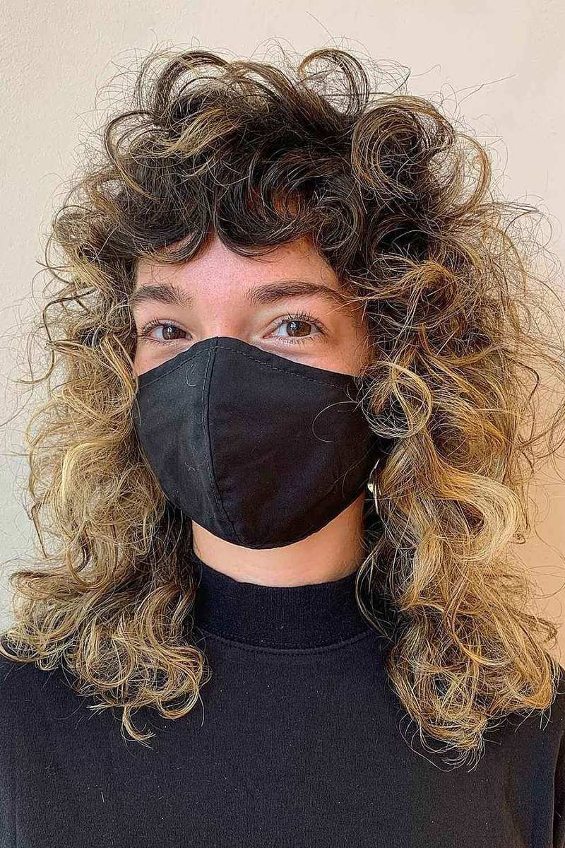 Medium curly wolf cut with blonde balayage ends, front view