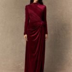 Woman in a glamorous burgundy velvet holiday gown, full-length portrait