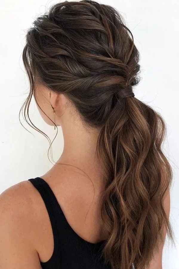 Rope twist half-up hairstyle gathered into a low wavy ponytail, back view