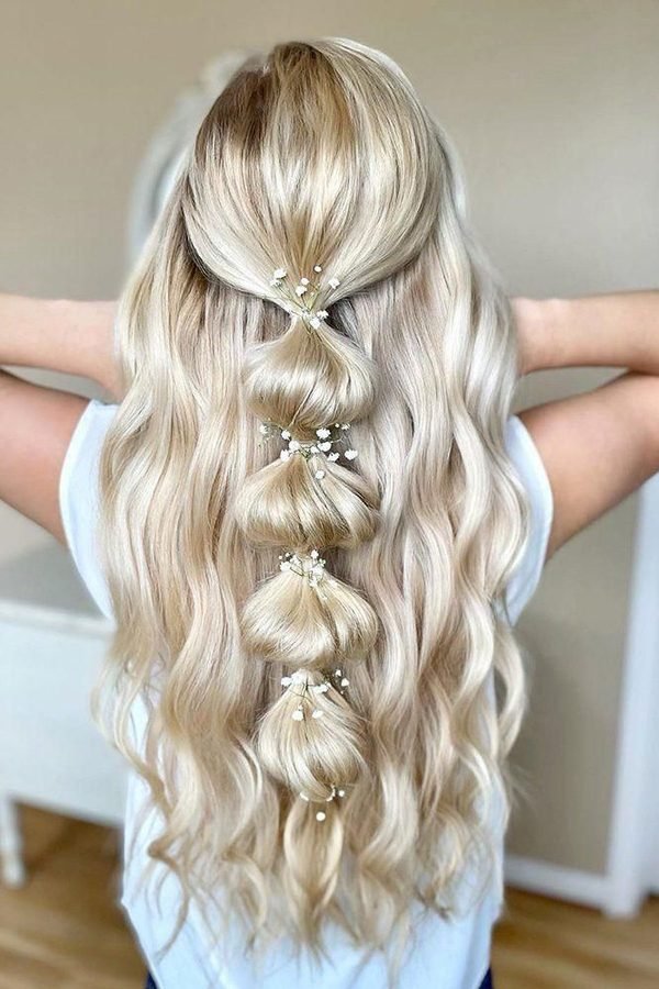 Half-up bubble ponytail with pearl accents on long blonde waves, back view