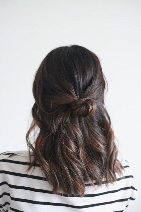 Simple half-up knot on shoulder-length wavy dark hair, back view