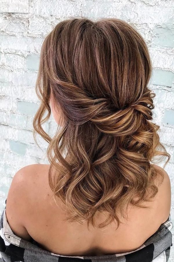 Half-up French twist roll with soft curls on highlighted brown hair, back view