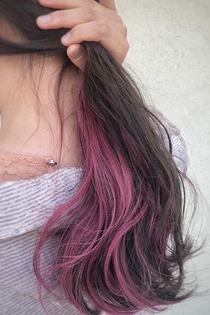 Magenta dark pink peekaboo underlayer on dark wavy hair, back view