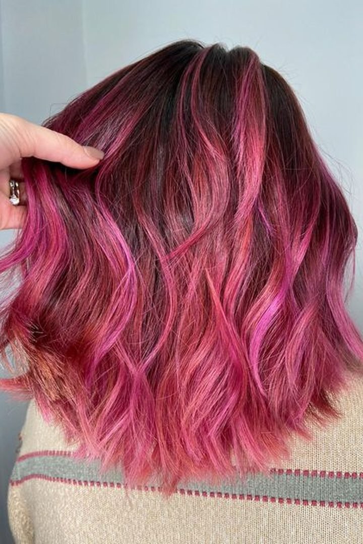 Rose pink peekaboo underlayer on dark wavy hair, back view