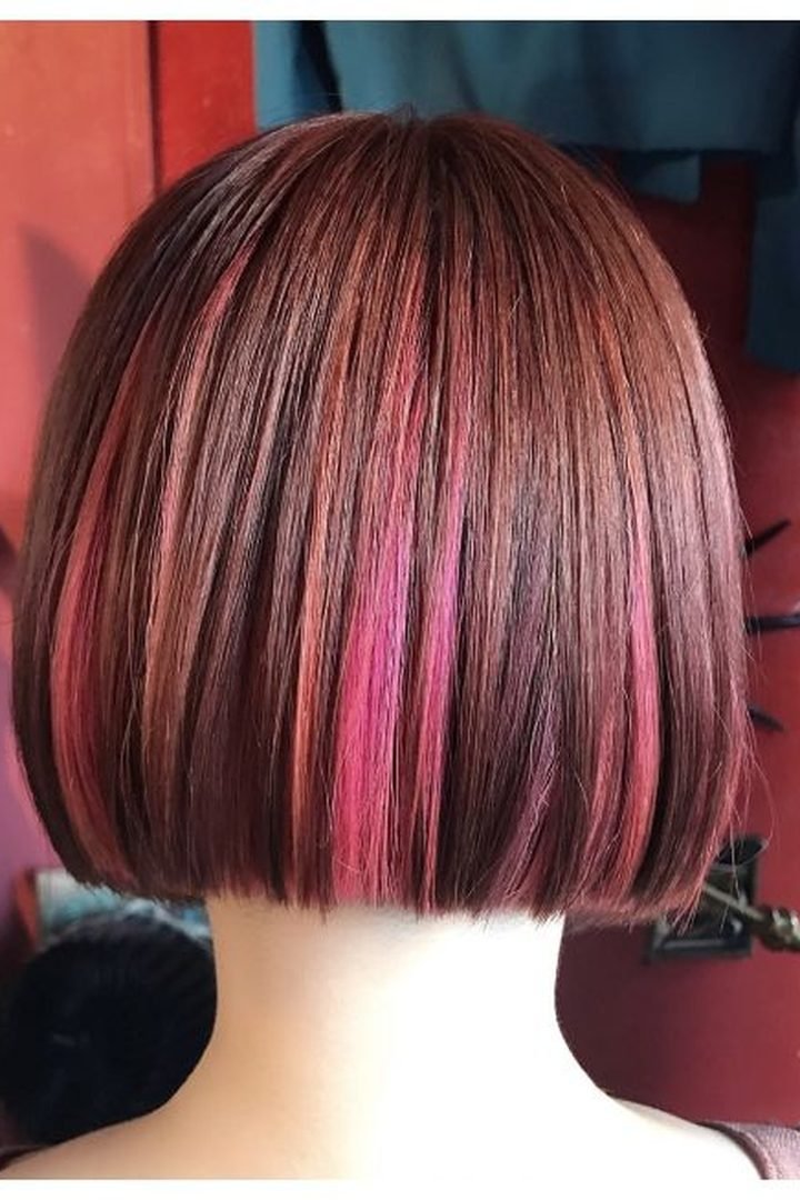 Subtle dark pink streaks peeking through a dark bob, back view