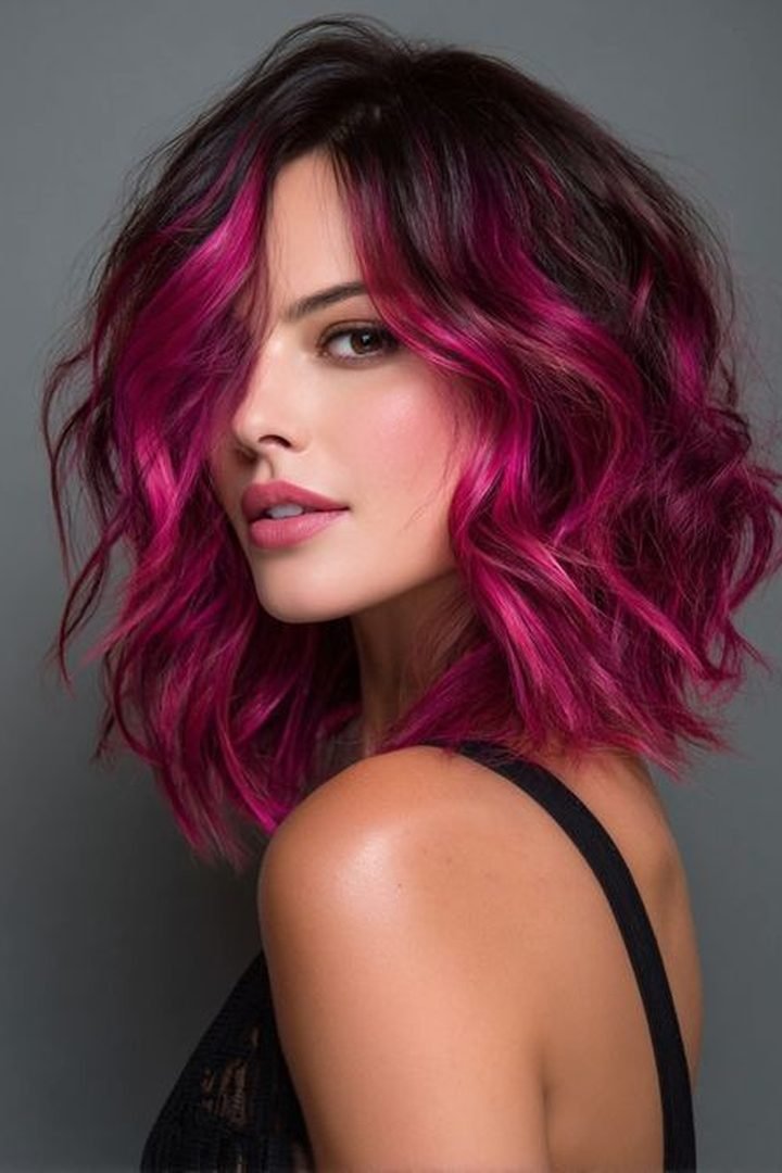 Magenta and pink dimensional peekaboo on wavy dark hair, front view