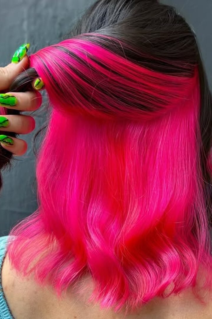 Neon hot pink peekaboo underlayer revealed on dark hair