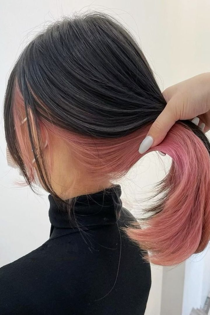 Dusty pink peekaboo underlayer revealed in a low ponytail