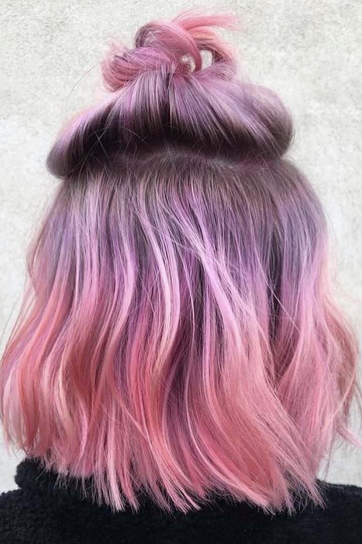 Pink and purple underlayer revealed in a half-up top bun