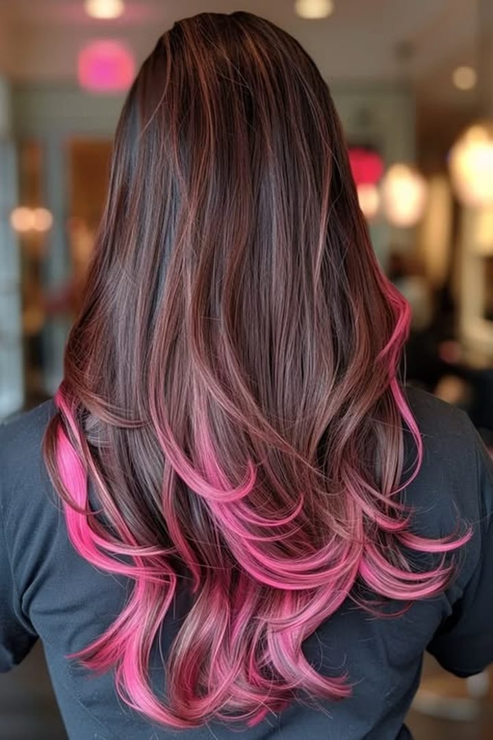 Hot pink peekaboo underlayer on dark wavy hair, back view