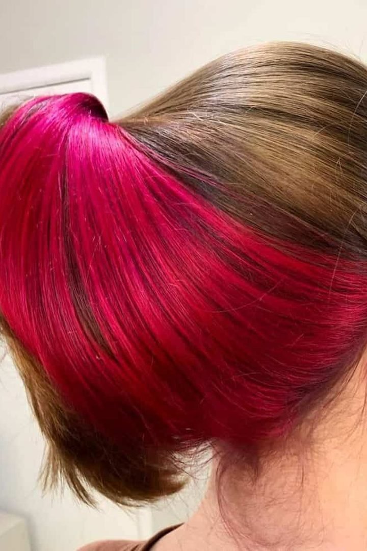 Red pink underlayer revealed in a low bun updo