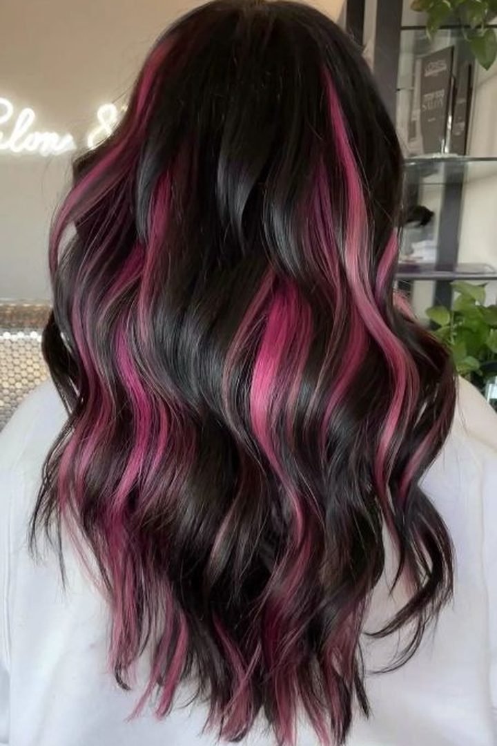 Wavy dark pink peekaboo underlayer on dark hair, back view