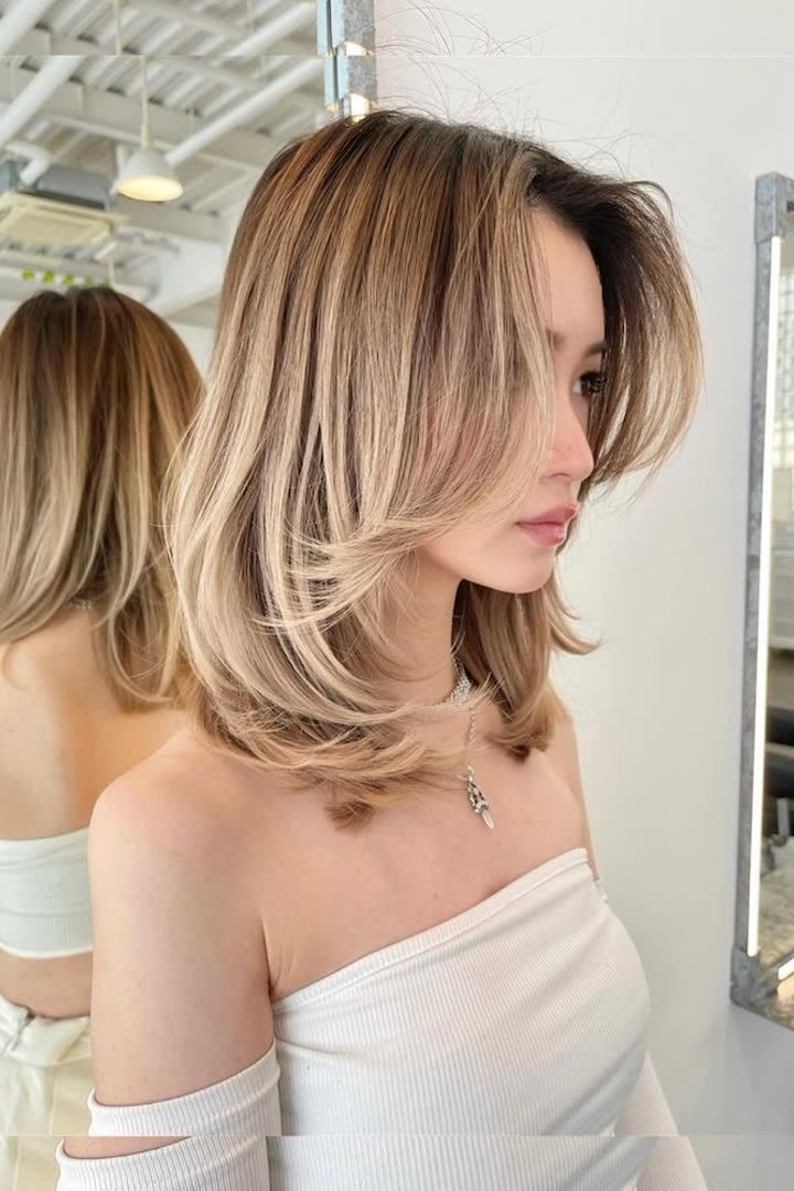 Classic kitty cut with soft feathered layers and a subtle fringe