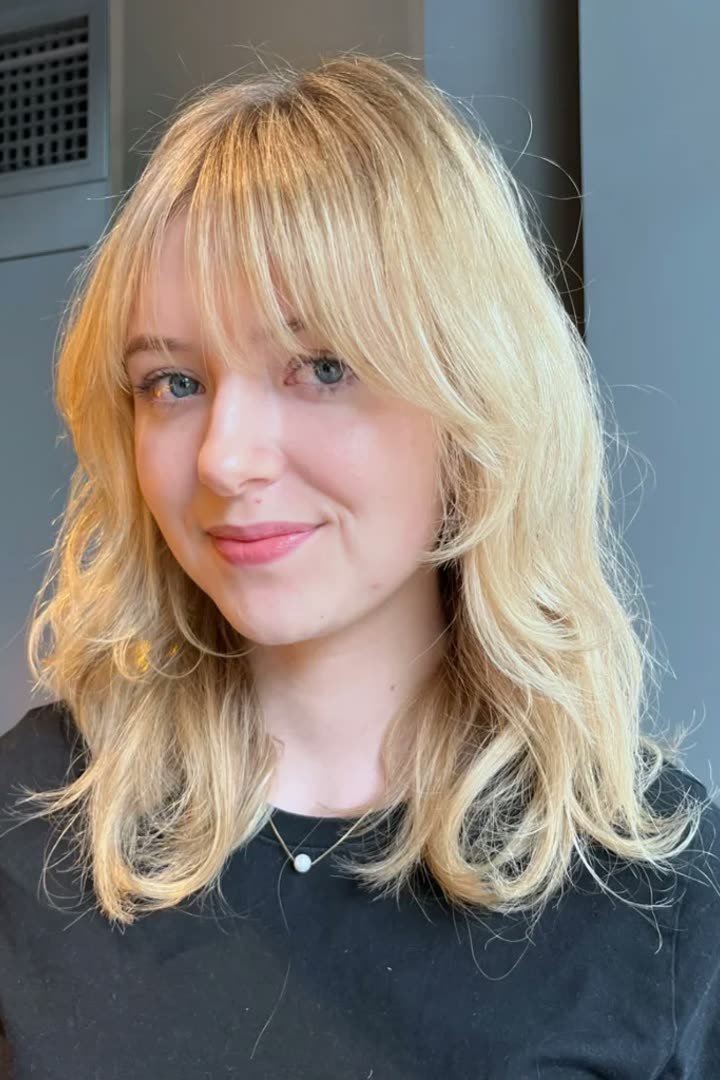 Kitty cut with center-parted curtain bangs and face-framing layers