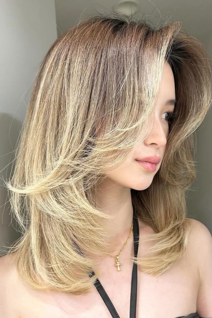 Long layered kitty cut with feathered layers falling past the shoulders