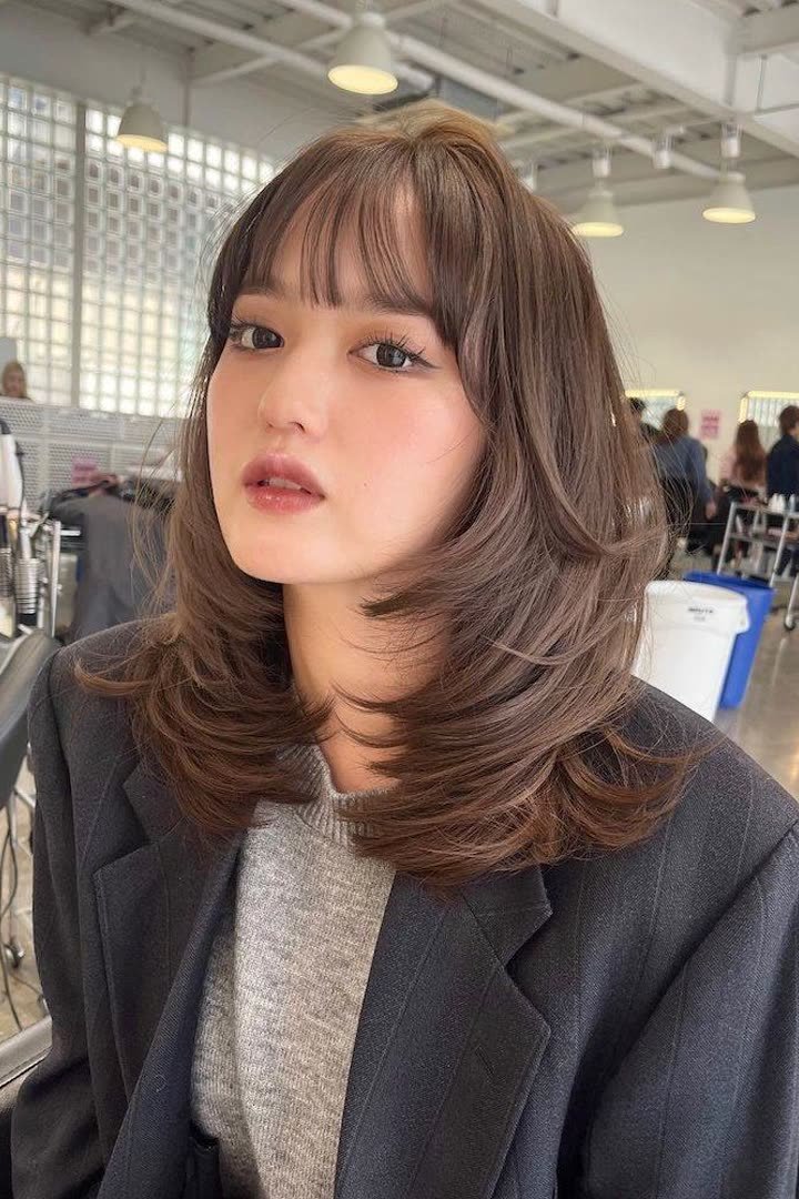 Kitty cut with a wispy brow-grazing fringe