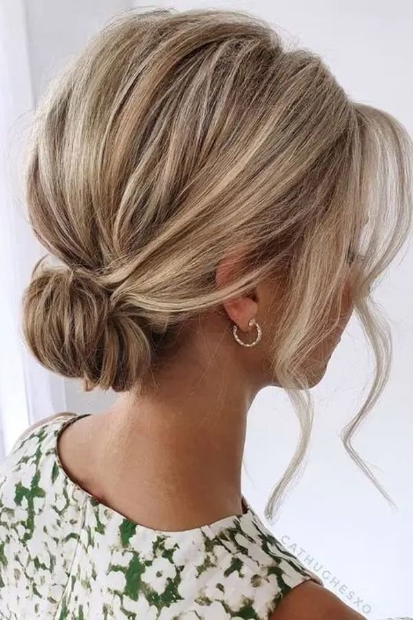 Loose low bun with face-framing tendrils, back view