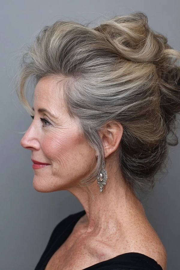 Polished high silver updo on an older woman, side profile