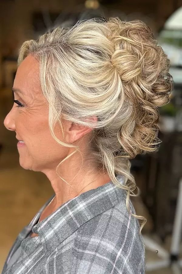 Textured blonde updo with loose curls, side profile