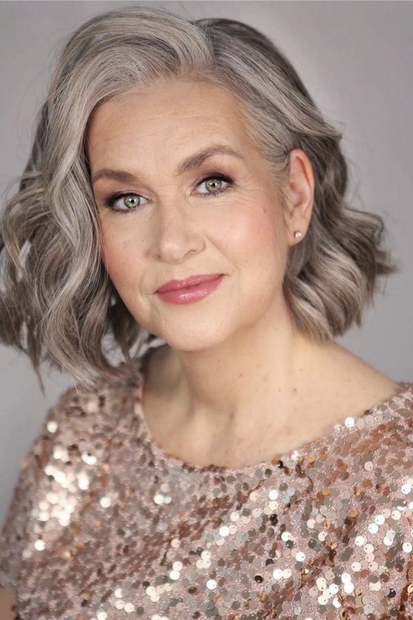 Silver wavy bob on a mother of the bride in a sequinned top, front view