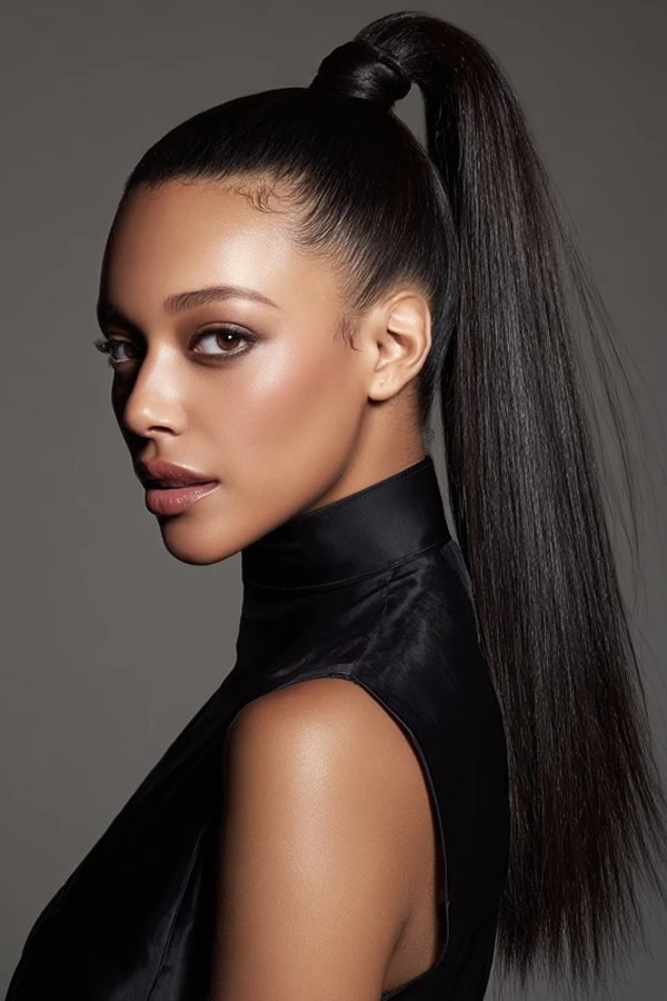 High sleek ponytail with hair wrapped around the base for New Year's Eve party