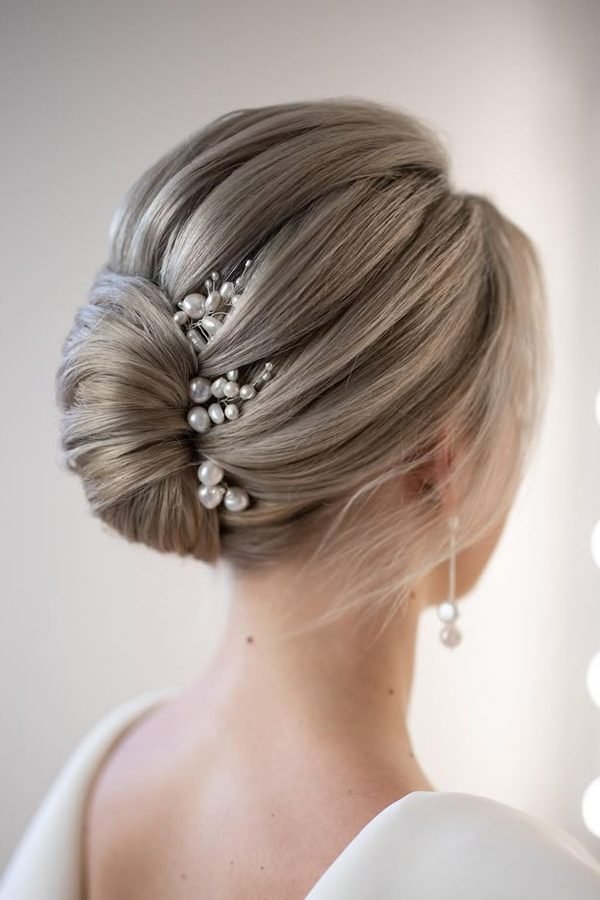 Low chignon with pearl accents for New Year's Eve party