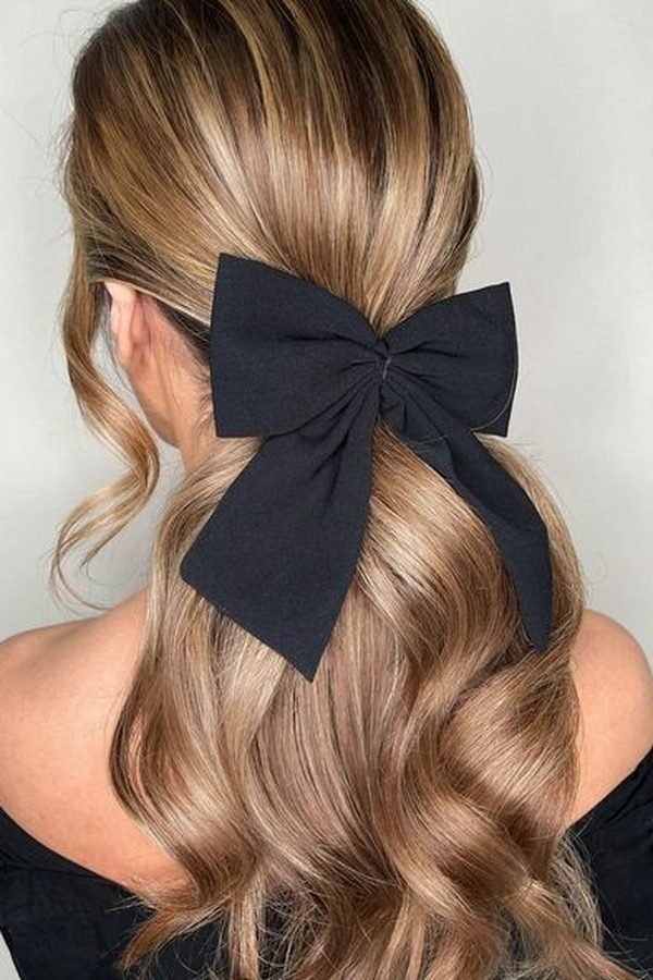 Wispy half-up hairstyle with bow clips for NYE