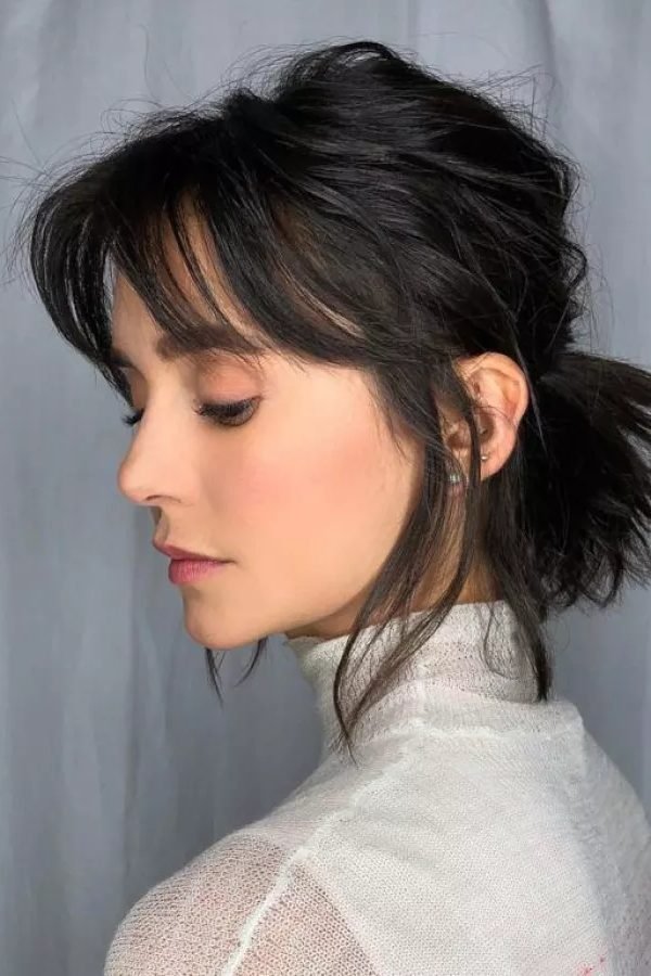 Short hair styled into a low ponytail, side view