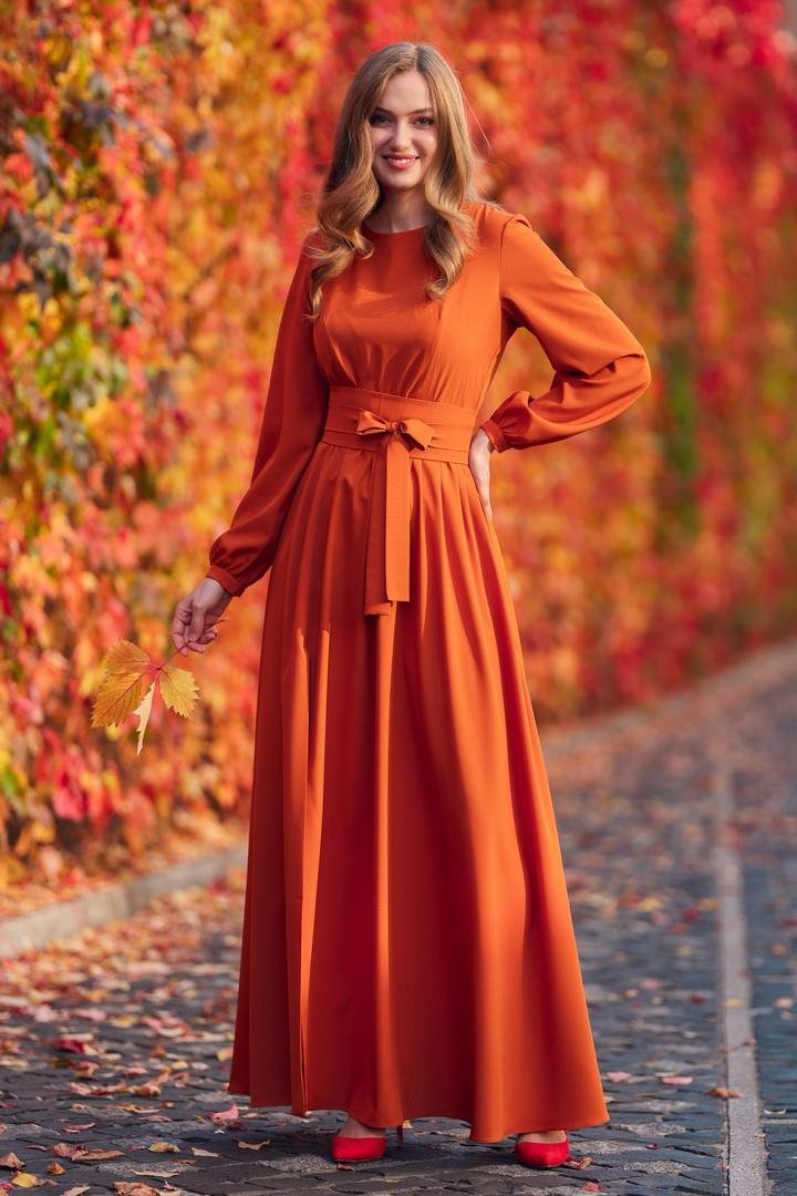 Pumpkin-orange long-sleeve maxi dress with a tie waist, worn with red heels