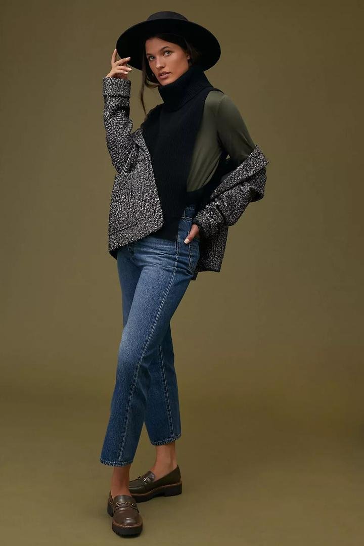 Tweed cropped jacket over a black turtleneck with straight-leg jeans and loafers