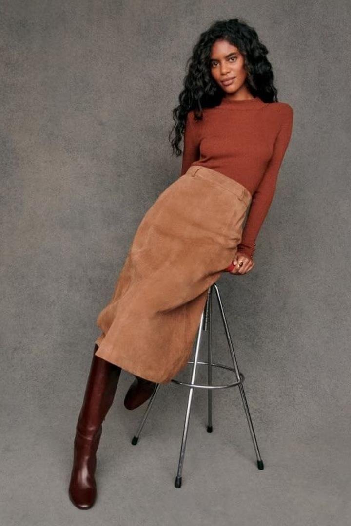 Rust fitted turtleneck with a tan suede midi skirt and burgundy knee-high boots