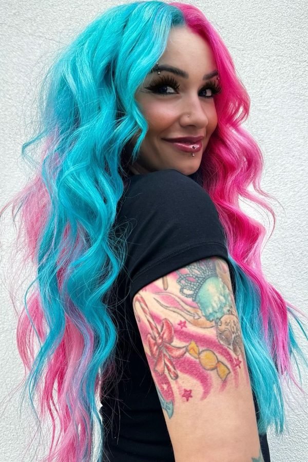 Split-dyed teal and pink hair styled in defined curls